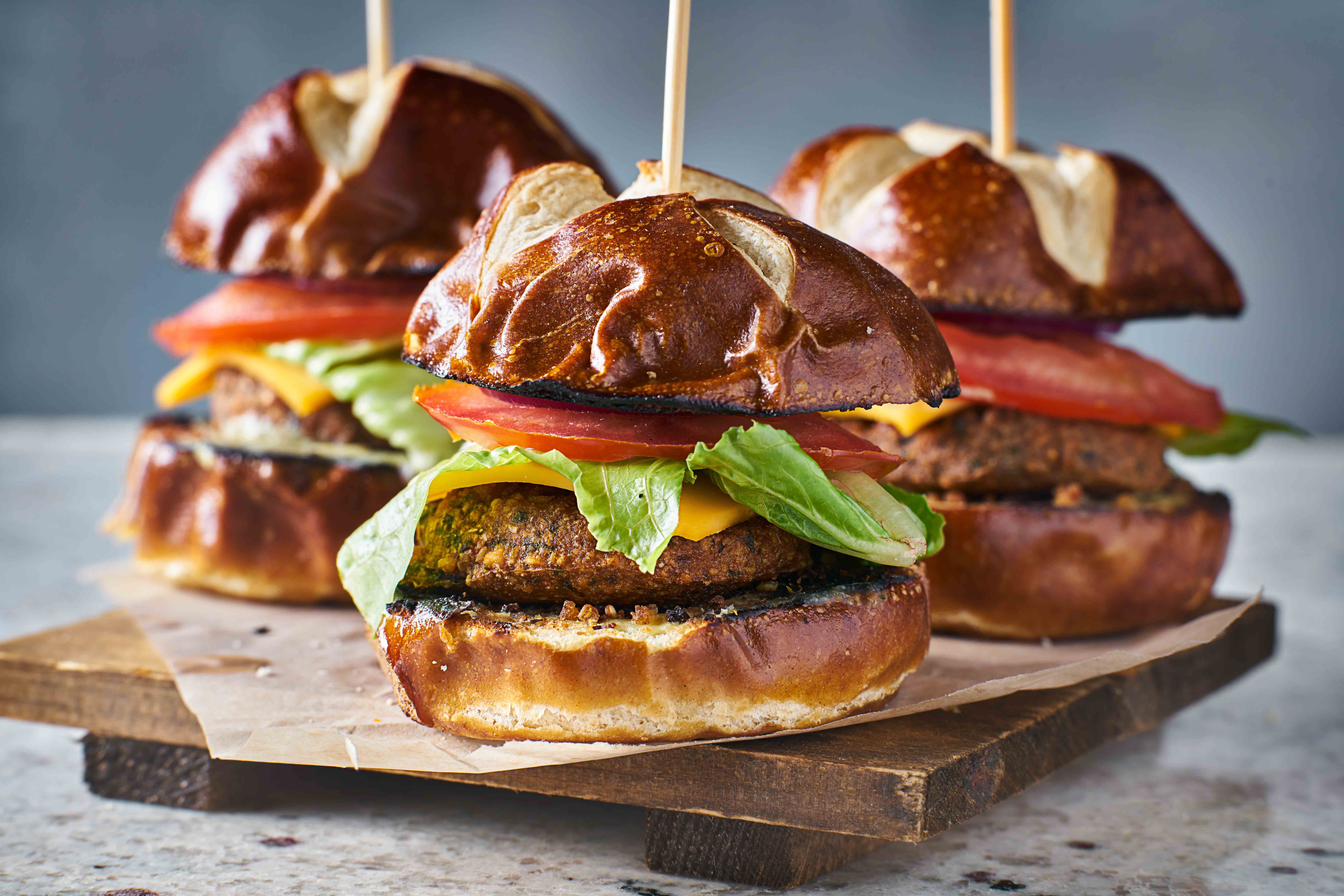three vegan burger sliders with pretzel buns